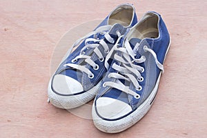 Pairs of canvas blue shoes on the wood background , dirty blue s with copy space