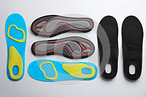 Pairs of insoles on light gray background, flat lay