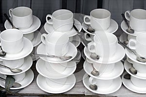 Pairs of mugs and plates with spoons in the window of the tableware store