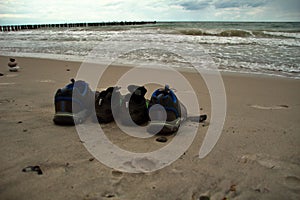 Pairs of shoes on the beach during summertime