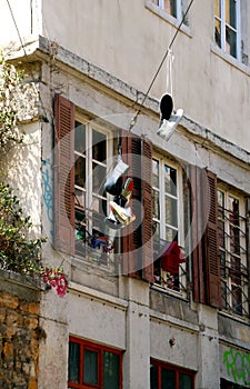 Pairs of sneakers hanging by street gangs from power lines on the streets of an Lyon city.