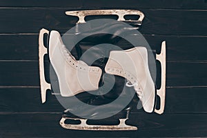 Pairs of white and black skates on wooden surface