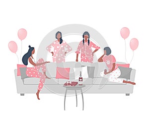 Pajama party. Slumber party. Young women in pajamas are sitting on the couch and talking. Some women are standing near the sofa