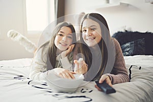 A pajama party with teens eat popcorn on the bed