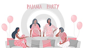Pajama party. Young women in pajamas are sitting on the couch and talking. Some women are standing near the sofa