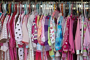 Second hand clothes in thrift shop night wear pajamas for kids girl pink flannel clothes rack photo