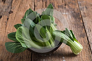 Pak Choy, fresh chinese cabbage on wood background photo