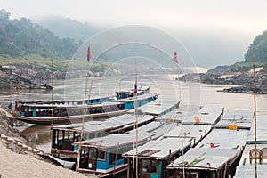 Pakbeng, Laos - Mar 04 2015: Slow boats at Mekong River in Pakbeng village. The village is the major stop for boats running