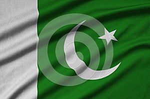 Pakistan flag is depicted on a sports cloth fabric with many folds. Sport team banner photo