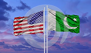 Pakistan and United States two flags on flagpoles and blue cloudy sky