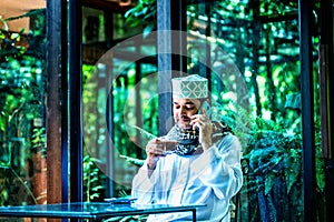 Pakistani muslim business Man talking on cellphone and drinking