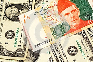 A Pakistani rupee bank note with American one dollar bills