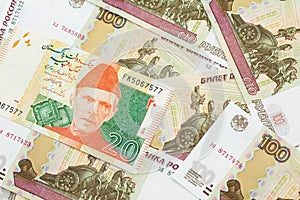 A Pakistani rupee bank note with Russian one hundred ruble bills