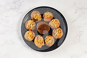 Pakistani spicy gol gappay, indian pani puri and bangali fuchka full of chaat masala with sour water in a dish isolated on marble