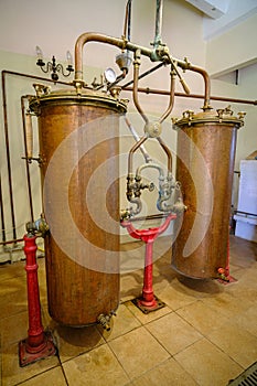 Pakruojis, Lithuania. July 7 , 2023: Industrial equipment for the production of alcohol. Copper is still alembic in the