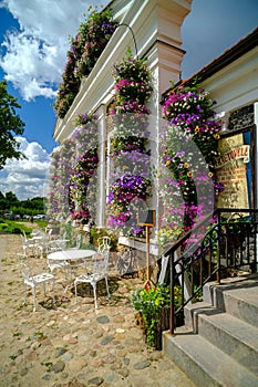 Pakruojis, Lithuania. July 7 , 2023: Old style garden furniture near a small restaurant. Walls with beautiful multi