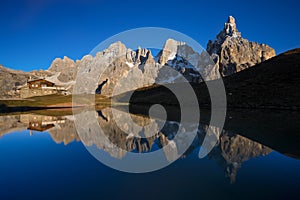The Pala Group reflecting on a lake as seen from Passo Rolle