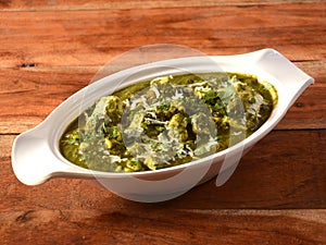 Palak Paneer Curry made up of spinach and cottage cheese, helathy indian traditional dish, served over a rustic wooden background