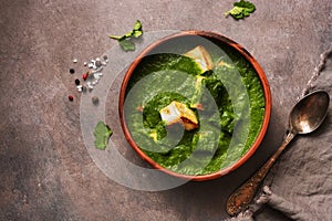 Palak paneer or Spinach and Cottage cheese curry on a dark background. Traditional Indian food. Top view, copy space