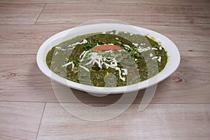 Palakpaneer or Spinach and Cottage Cheese curry, mortar with spices on dark background. Traditional Indian dish. Top view, copy