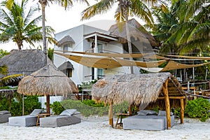 Palapa thatched roofs palms parasols sun loungers beach resort Mexico