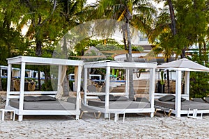 Palapa thatched roofs palms parasols sun loungers beach resort Mexico