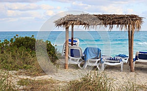 Palapas and lounge chairs overlooking the ocean n