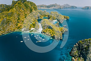 Palawan, Philippines aerial view of tropical Miniloc island. Tourism trip boats at big lagoon entrance. Natural scenery photo