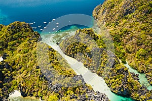 Palawan, Philippines aerial view of tropical Miniloc island. Tourism trip boats moored at entrance to big lagoon photo