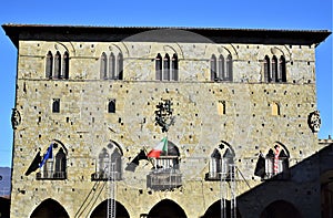 Palazzo del Comune, framed by the blue sky, in piazza del duomo in Pistoia illuminated by the sun.