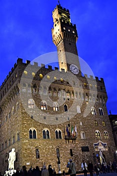 Palazzo Vecchio illuminated by the lights on for the evening that advances, but with the sky still blue, in Florence.