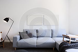 Pale blue linen sofa and blank pictures in a living room