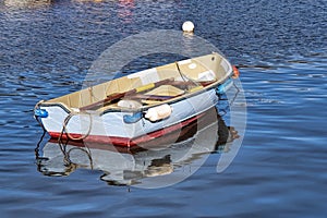 Pale Blue Skiff Reflected in Calm Harbour Waters