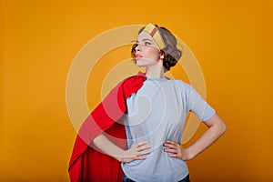 Pale girl in superhero costume looking away with serious face expression. Studio shot of brown-haired female model