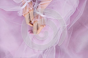 Pale pink nail design. Female hands with pale pink manicure. Female in pink dress with pale pink thumbs fingernails