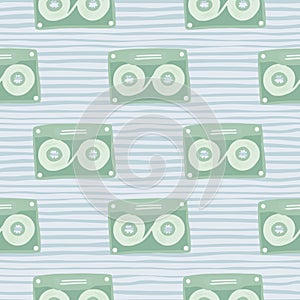 Pale stylized seamless cassette pattern. Light green music disco ornament on blue soft stripped background