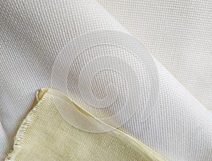 Pale yellow and milk white folded canvas. Fabric texture background