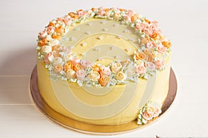 Pale yellow mousse cake with pastel cream flowers