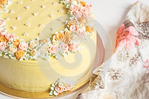 Pale yellow mousse cake with pastel cream flowers