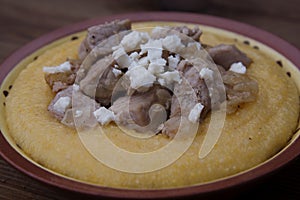 Palentawith meat over rustic wooden background. Traditional food