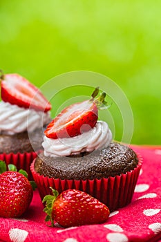 Paleo chocolate cupcakes with coconut cream and strawberries