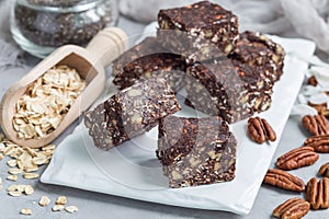 Paleo chocolate energy bars with rolled oats, pecan nuts, dates, chia seeds and coconut flakes