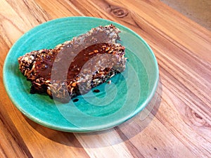 Paleo, vegan seedy bread topped with marmite, on green plate photo
