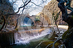 Paleokarya old stone arched bridge between two waterfalls. Trikala prefecture, Greece