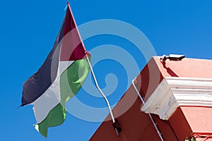 Palestine flag waving against clean blue sky