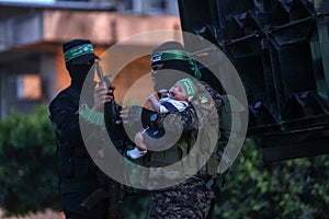Members of the Ezz-Al Din Al-Qassam Brigades, the armed wing of the Hamas movement, take part in a military parade in a street in