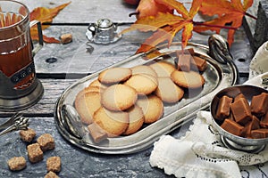 Palets bretons, french cookies. Salted caramel Shortbread Breton cookies, cup of tea and autumn leaves photo