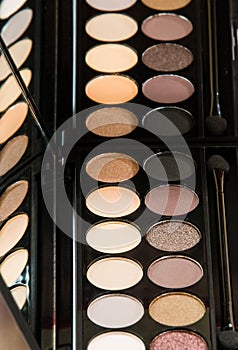 Palette of eye shadow close-up reflected in mirror.