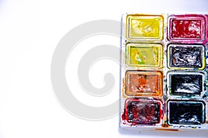 Palette with watercolors and brushes for paints on a white background
