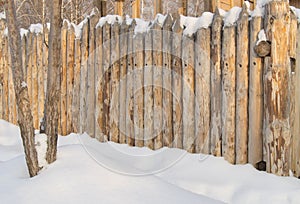 Paling, Wooden fence made of logs in the village, winter